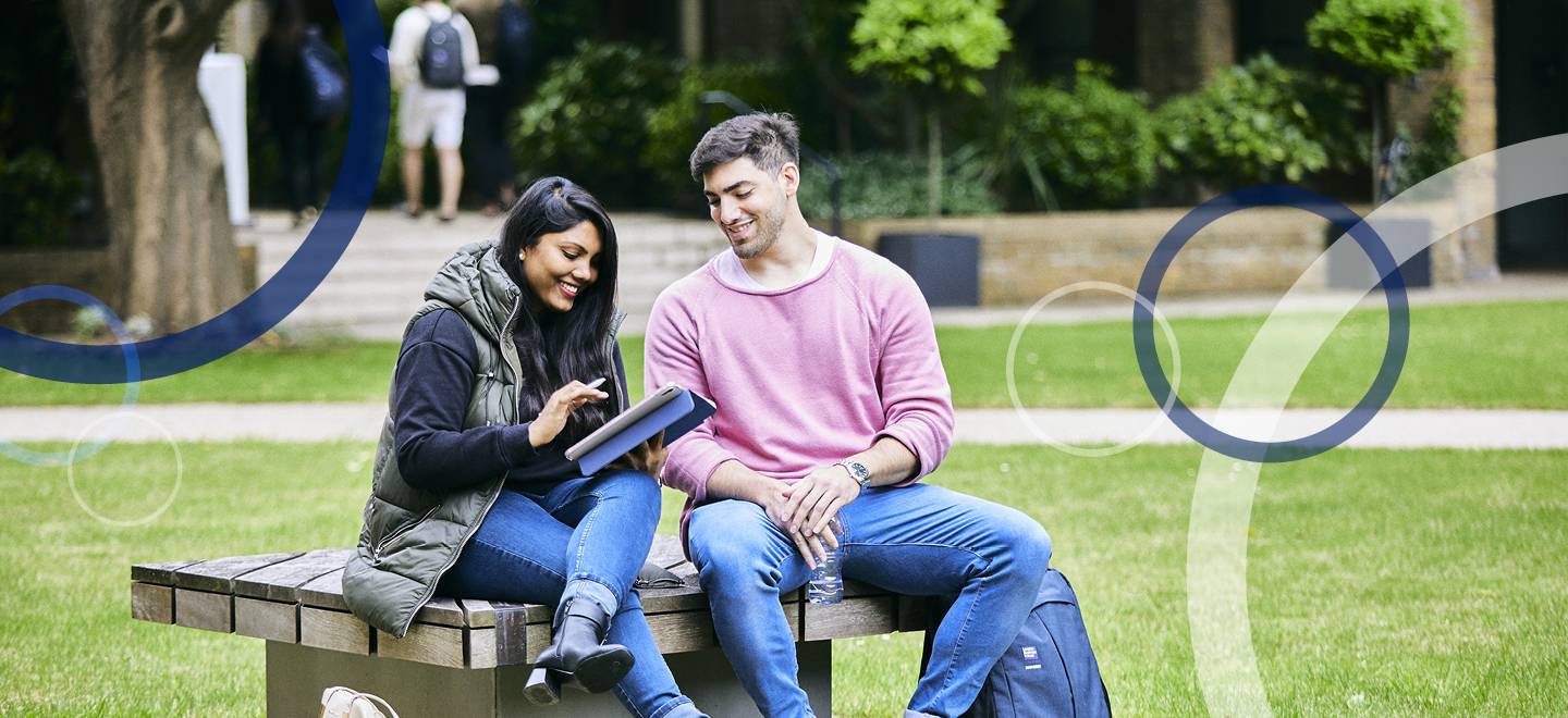 2 LBS students sitting on a bench chatting