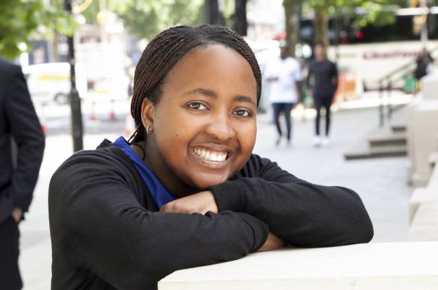 LBS scholar smiling and folding arms